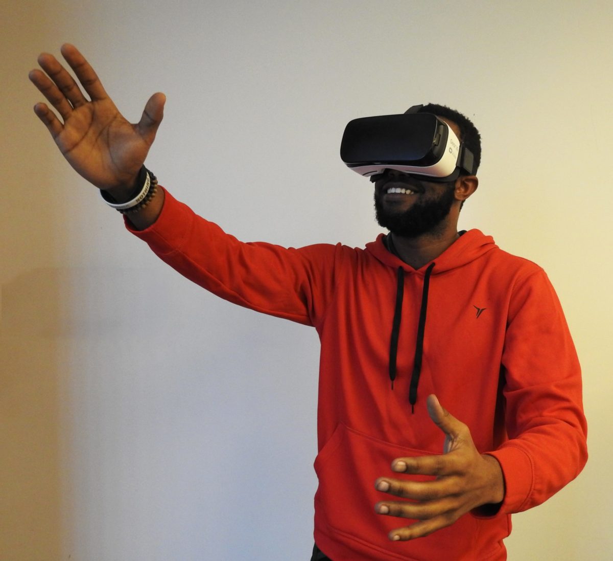 A man in a red hoodie using a VR headset